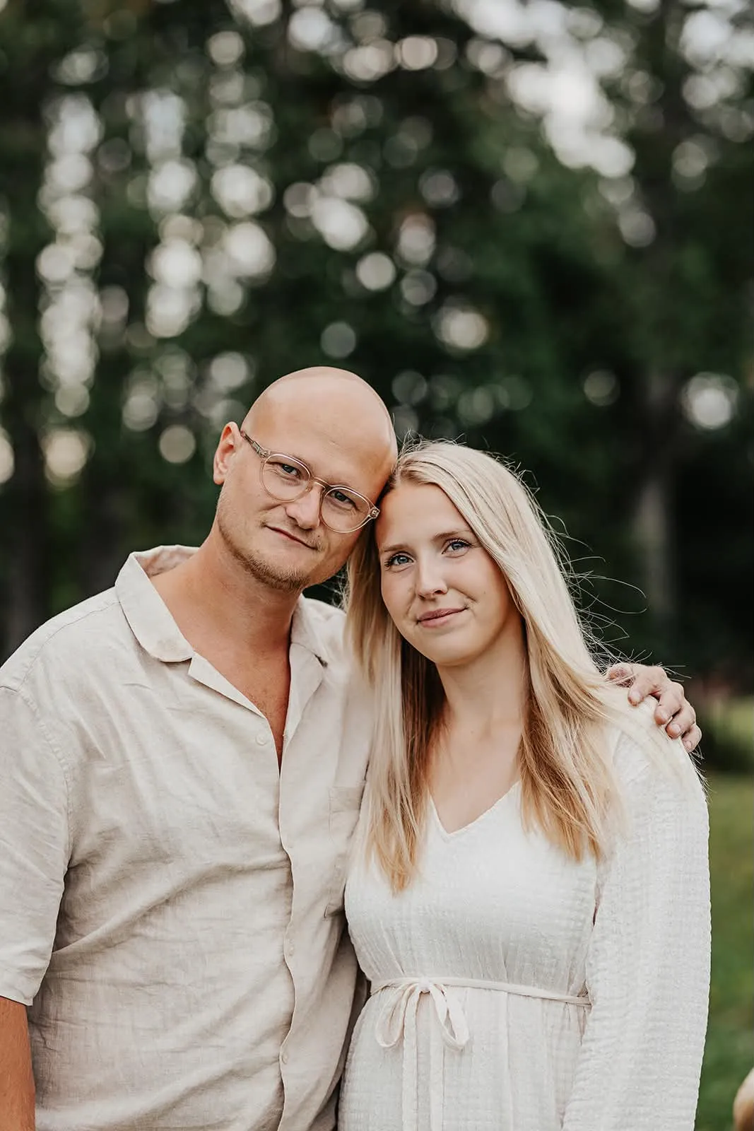 Marius och Evelina, kind mot kind, framför sommargröna träd